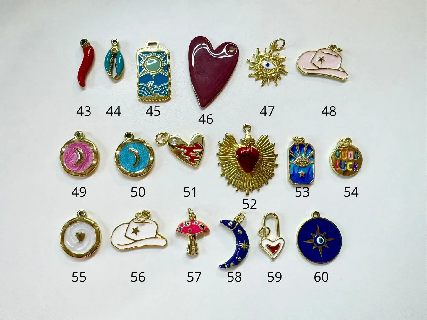 Variété de pendentifs pour Collier a personnaliser, incluant cœurs, étoiles et autres designs.