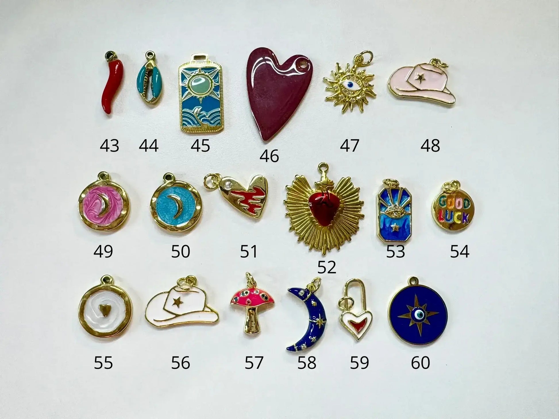 Variété de pendentifs pour Collier a personnaliser, incluant cœurs, étoiles et autres designs.